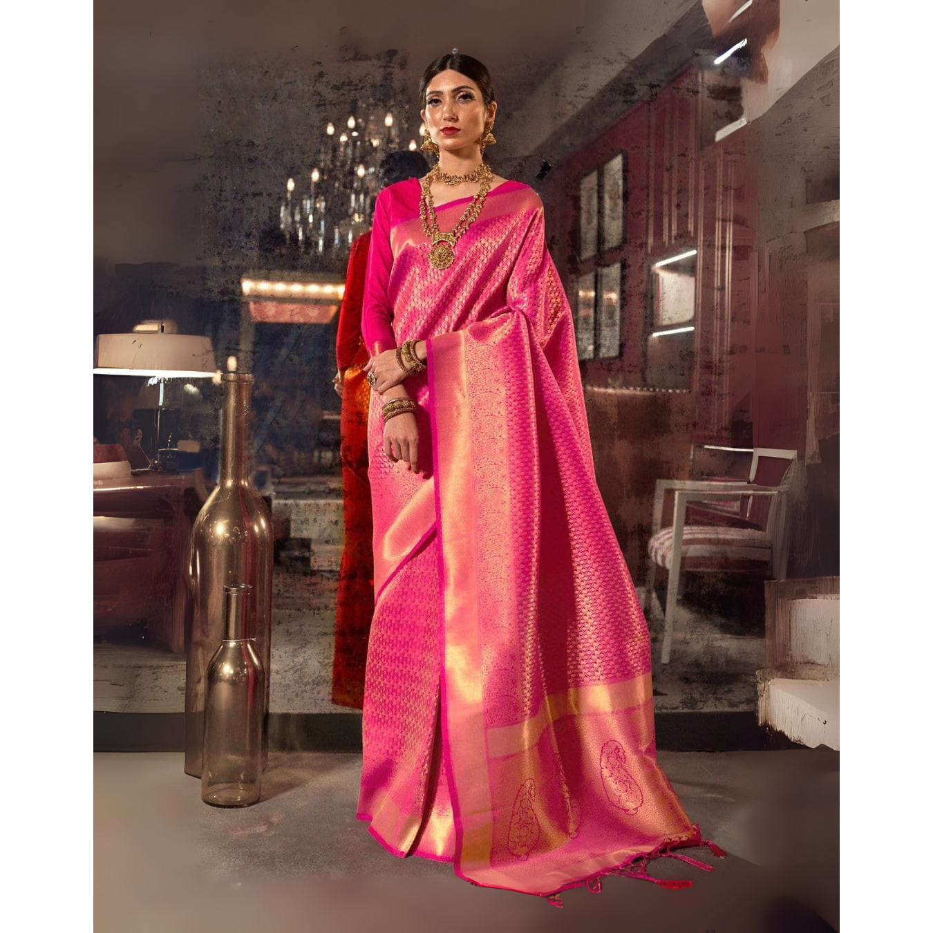 Woman in a bright pink saree with gold patterns standing in an indoor setting.